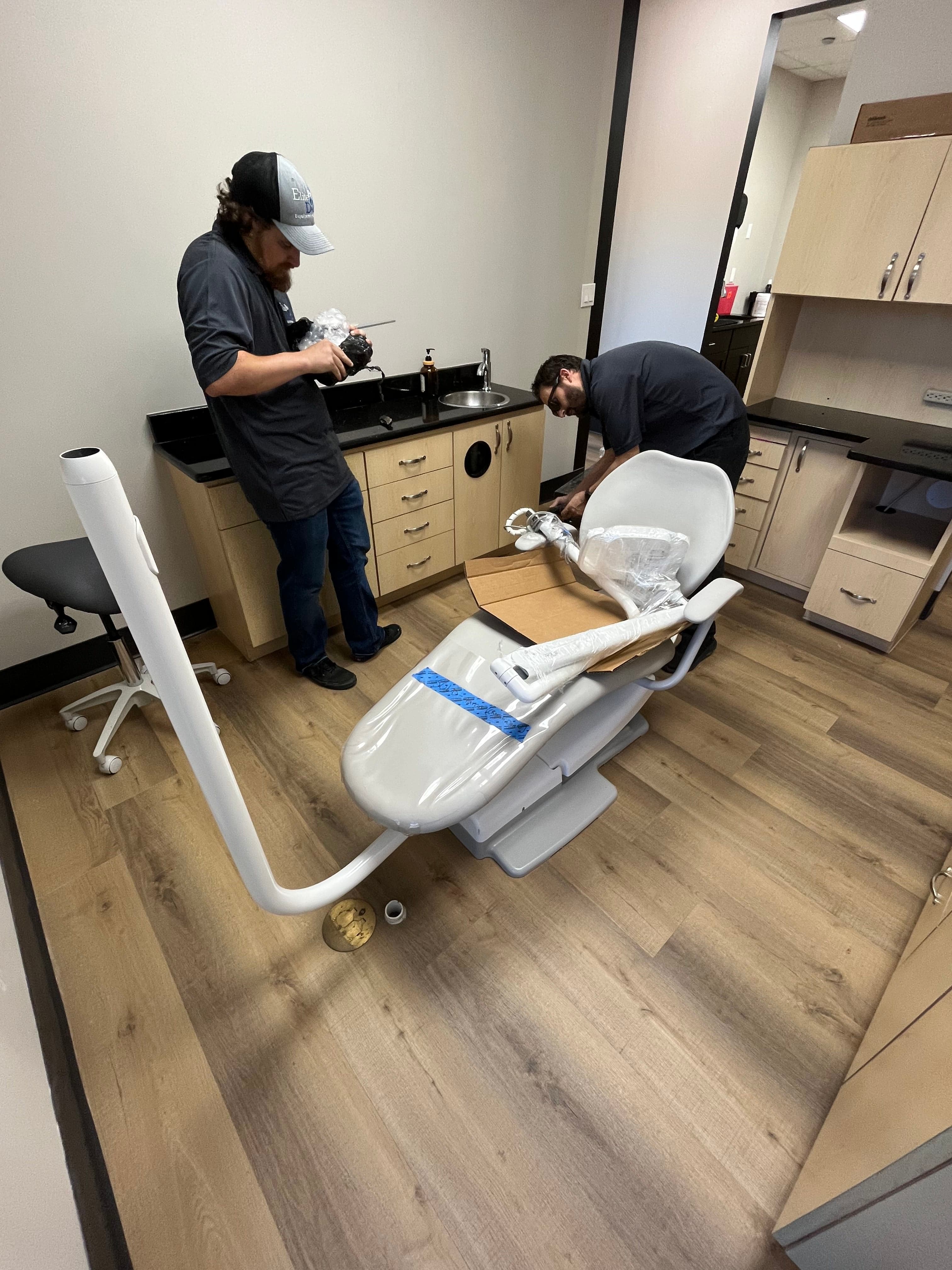 Professional dental equipment technician installing A-dec chair